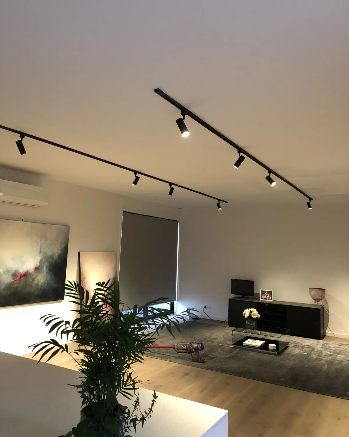 Lámpara Atelier: rieles negros con focos orientables iluminando una sala